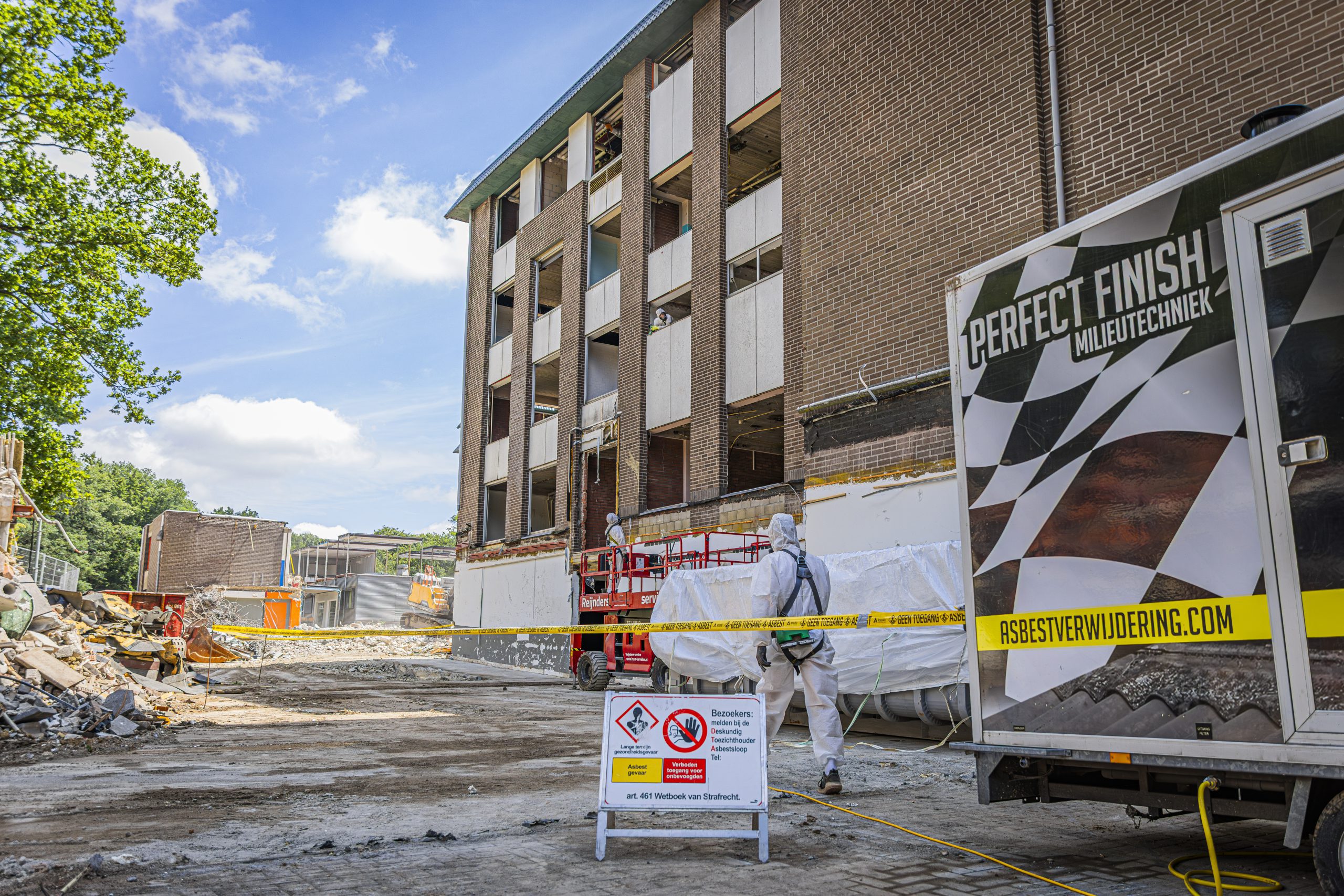 Asbestverwijdering bouwplaats met beschermende kleding