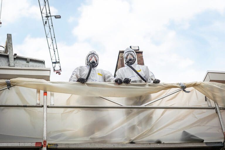 Mannen in asbest beschermingskleding aan het werk